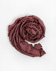 Maroon shawl with tassels on a white background